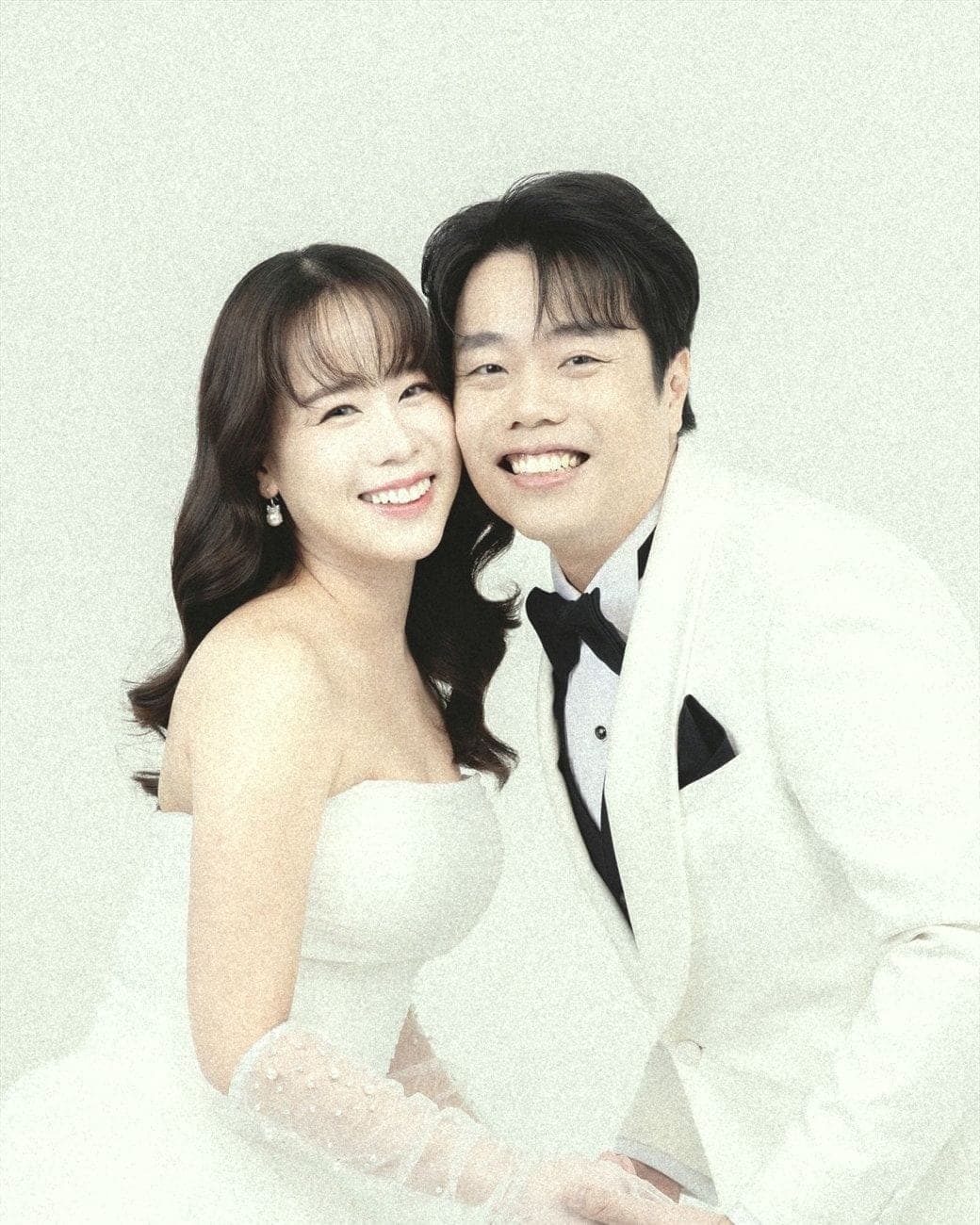 Witita and Sorratat cheek to cheek in white tuxedo and gown